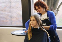 PHM student getting hair cut for "Short Hair Because we Care" hair donation event