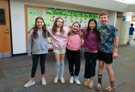 Students seated at desks in a classroom, looking towards the camera.
