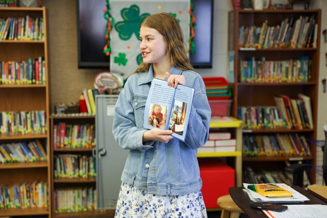 Student reading a book in a classroom.