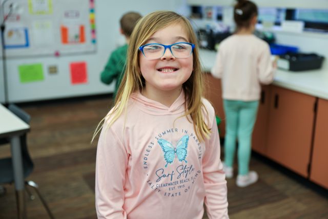 Smiling girl in classroom.